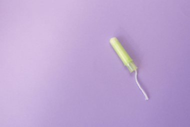 Menekşe zemininde tıbbi kadın tamponu. Kadınlar için hijyenik beyaz tampon. Pamuklu bez. Adet, koruma kavramı, düz yatıyordu, Kopyalama alanı