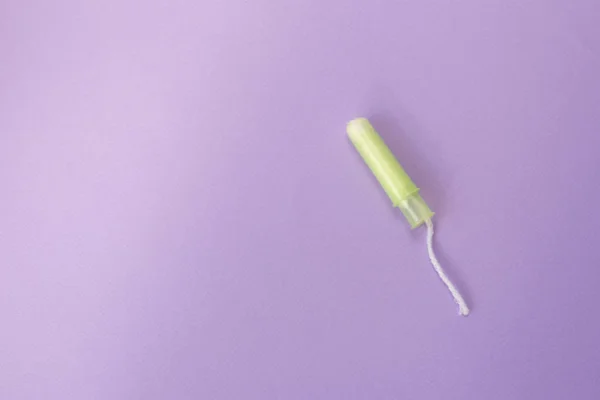 Tampão feminino médico em um fundo violeta. Tampão branco higiénico para mulheres. Um cotonete. Menstruação, conceito de proteção, flat lay, espaço de cópia — Fotografia de Stock