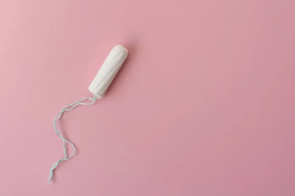 Tampão feminino médico em um fundo rosa. Tampão branco higiénico para mulheres. Um cotonete. Menstruação, conceito de proteção, flat lay, espaço de cópia, vista superior — Fotografia de Stock