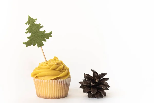 Noel ağacı ve beyaz arka plan üzerinde izole bir koni ile Taze sarı cupcake. Kutlama kompozisyonu, tatil konsepti, kopyalama alanı