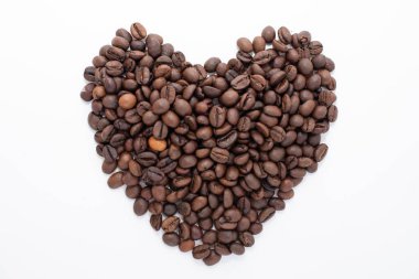 Kalp, beyaz arka planda izole edilmiş kahve çekirdeklerinden yapılmış. Kahve dükkanı konsepti