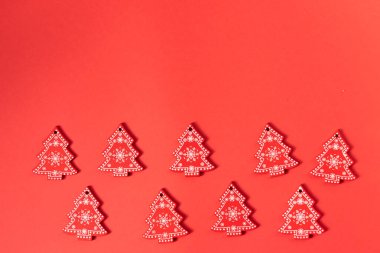 Kırmızı arka planda süslemeleri olan küçük kırmızı noel ağaçları metin ve xmas süslemeleri için fotokopi alanı. maketleme