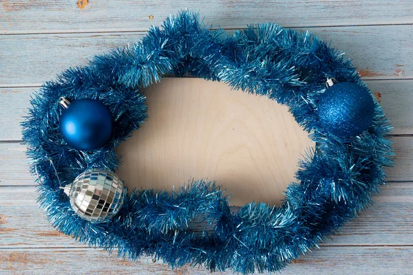 Mavi Noel süslemesi boş bir antika ahşap tablet ve mavi ahşap zemin ile çevrilidir. Mavi taşaklı Noel kompozisyonu. Yeni yıl, kış tatili konsepti, kopyalama alanı