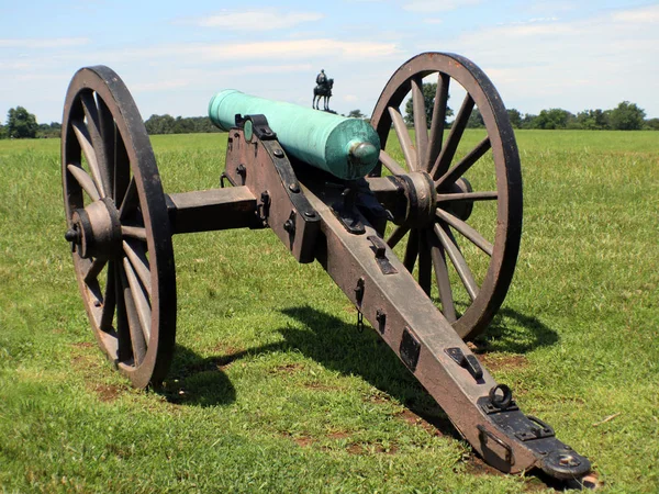 Civil war cannon with man on a horse in the background