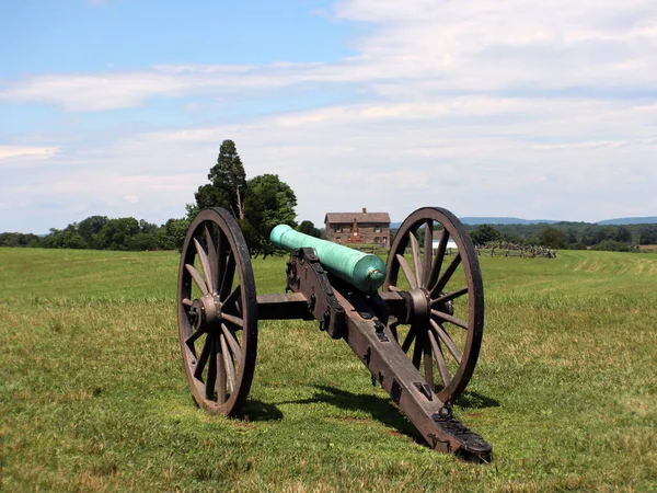 Civil war cannon with house in background