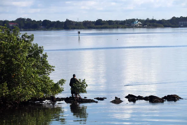 Bir adam kayalar kıyı boyunca gelen Balık tutma