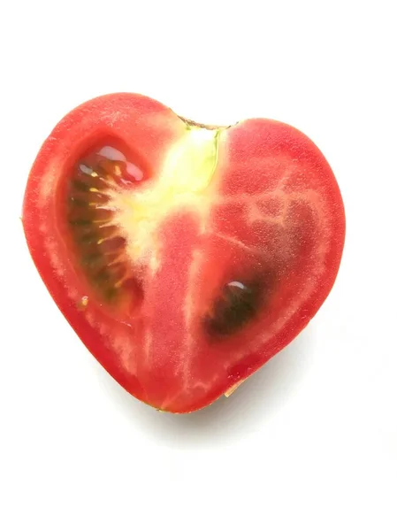 Фото спелого вырезанного помидора в форме сердца, изолированного поверх белого — стоковое фото