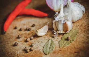 Biber baharat, sarımsak, biber ve ahşap masa üzerine defne