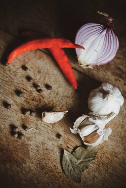 Biber baharat, sarımsak, biber ve ahşap masa üzerine defne