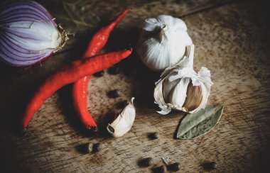 Biber baharat, sarımsak, biber ve ahşap masa üzerine defne