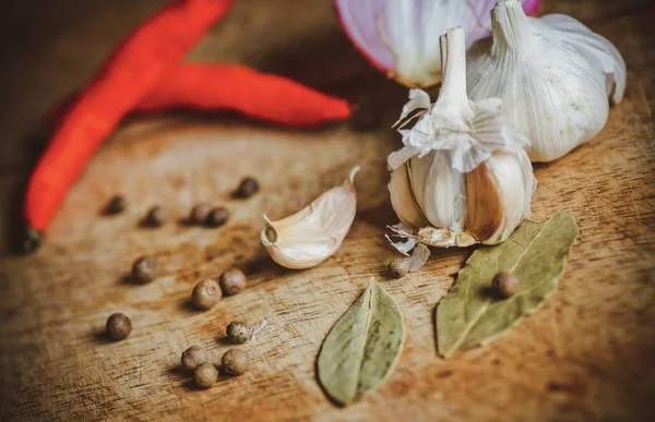 Biber baharat, sarımsak, biber ve ahşap masa üzerine defne