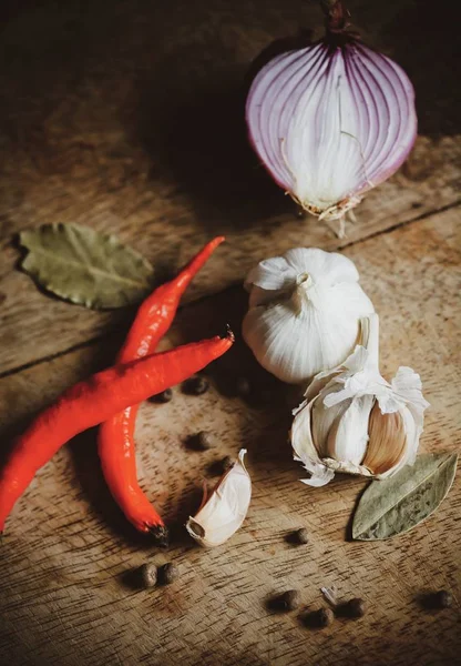 Biber baharat, sarımsak, biber ve ahşap masa üzerine defne
