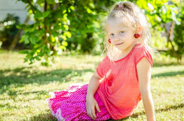 Ładny Blond Dziewczyna Owoców Wiśni Uszach Siedzi Zielonej Trawie — Zdjęcie stockowe