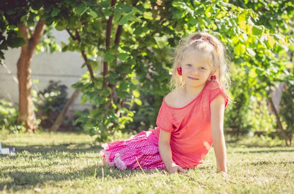 Adorável Menina Loira Com Fruta Cereja Orelhas Sentadas Grama Verde — Fotografia de Stock