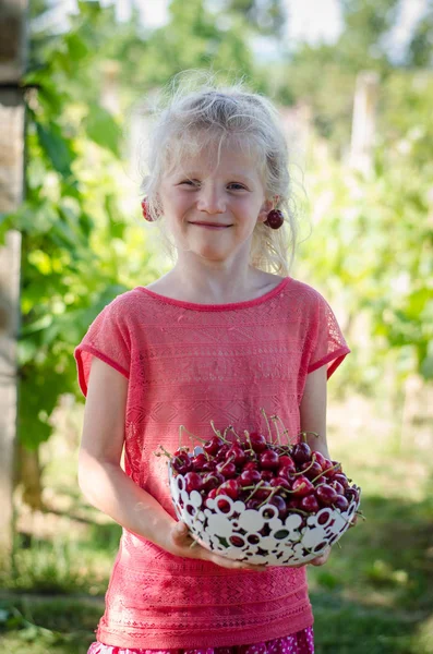 かわいいブロンドの女の子の手で桜の果実と — ストック写真