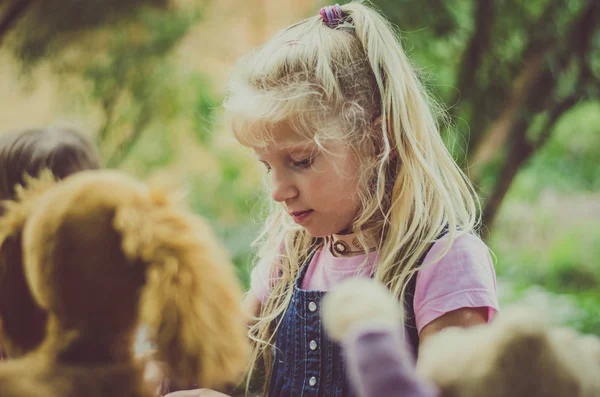 長い髪のふわふわおもちゃで遊んでのかわいいブロンドの女の子 — ストック写真