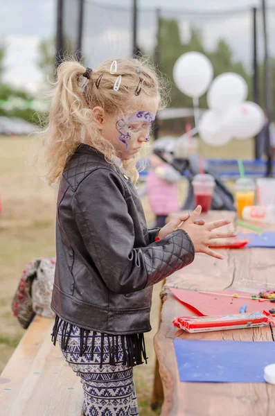 かわいいブロンドの女の子遊び生地で遊んでいるとテーブルの上の図を作成します — ストック写真