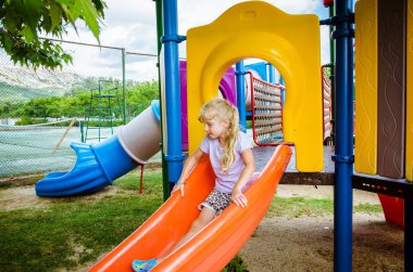 slayt içinde eğlenmek uzun saçlı sevimli küçük sarışın kız