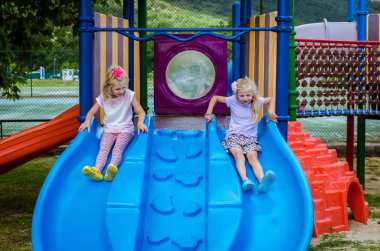 Slayt içinde eğlenmek uzun saçlı sevimli küçük sarışın kız