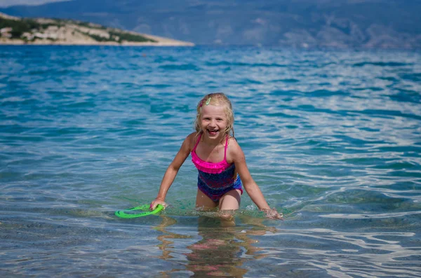 可爱的小金发女孩在海里游泳和微笑 — 图库照片