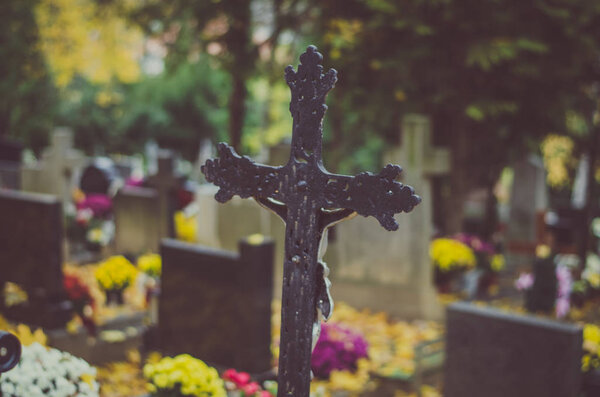 cross  grave in the cemetery at All Saints Day in autumn time