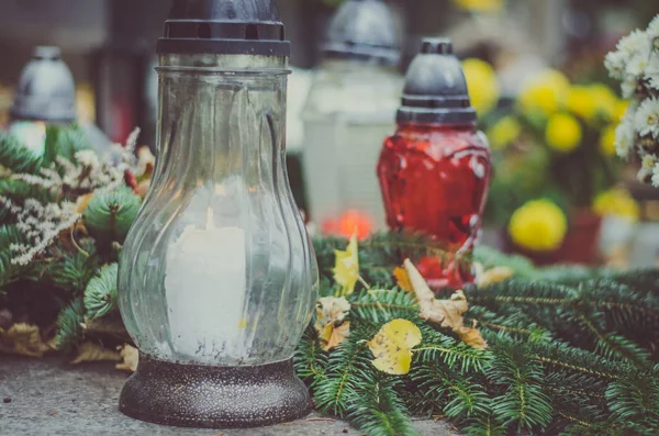 candle decoration on grave in the cemetery at All Saints Day in autumn time