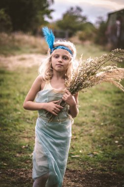 garip çocukla elbise ve elinde çiçekler