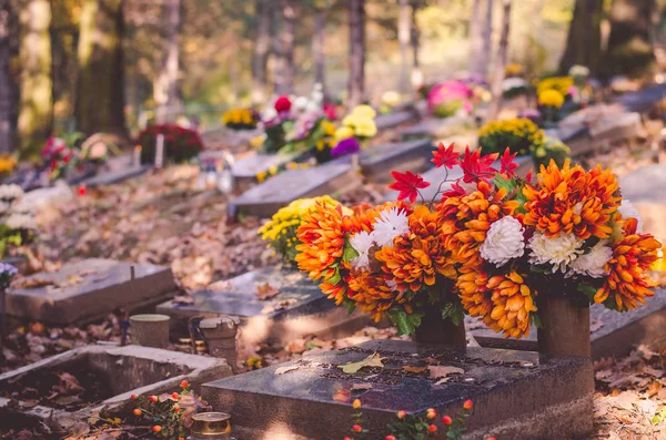 graves with All Saint Day decoration and leaves in autumn atmosphere