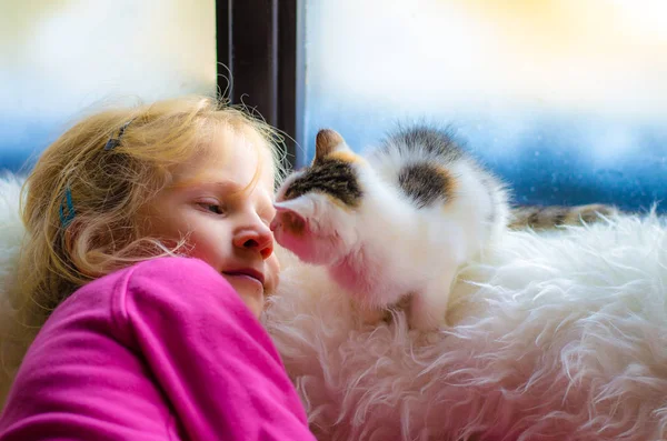 Güzel Sarışın Kız Bir Kedi Pencerenin Kış Döneminde Gözlerine Bakıyor — Stok fotoğraf