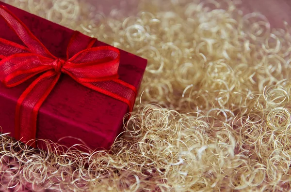 shining red christmas box with surprise inside in golden background
