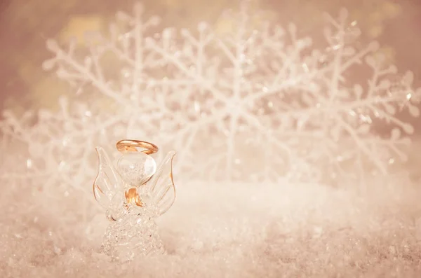 玻璃天使和简单的白色雪花装饰在柔和的雪的背景 — 图库照片