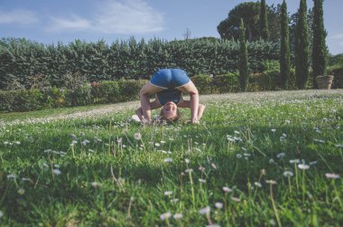 yeşil çayır çiçek tam komik akrobatik duruş ile kız