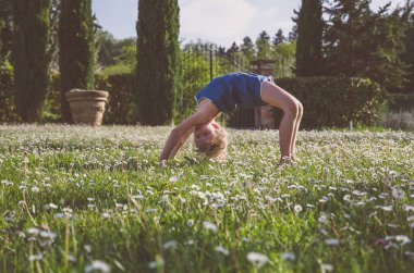 yeşil çayır çiçek tam akrobatik duruş ile kız