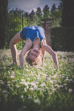 yeşil çayır çiçek tam akrobatik duruş ile kız