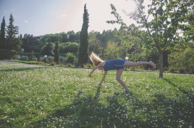 yeşil çayır çiçek tam akrobatik duruş ile kız