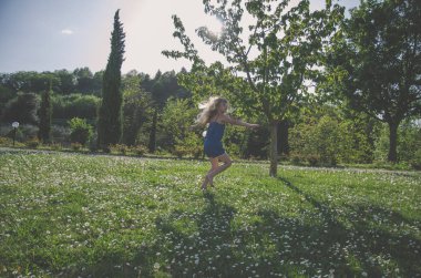 yeşil çayır çiçek tam akrobatik duruş ile kız