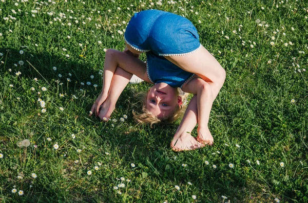 Lány Zöld Rét Virágokkal Teli Vicces Akrobatikus Testtartás — Stock Fotó