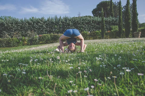 yeşil çayır çiçek tam komik akrobatik duruş ile kız
