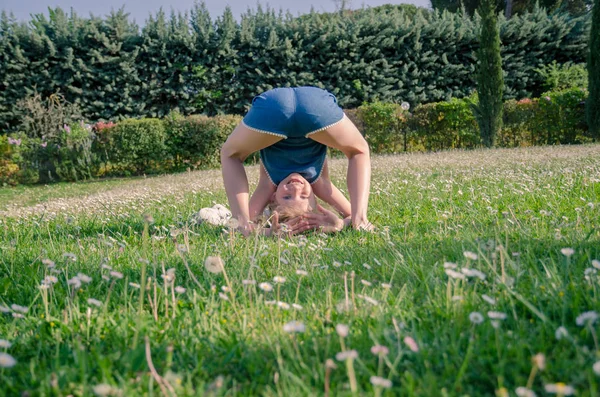 yeşil çayır çiçek tam komik akrobatik duruş ile kız