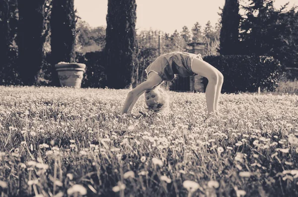 Fille Avec Posture Acrobatique Dans Prairie Verte Pleine Fleurs Rétro — Photo