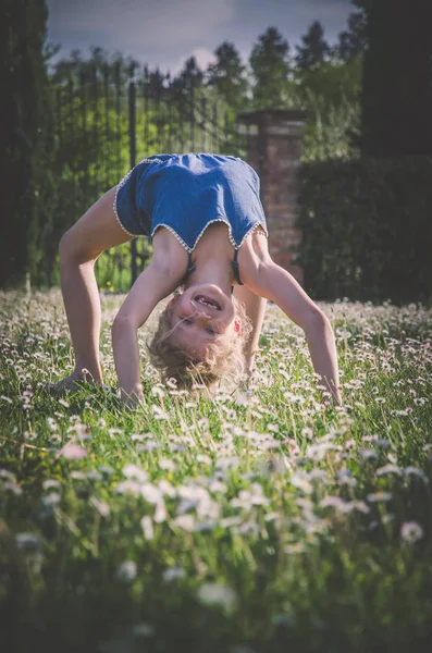 yeşil çayır çiçek tam akrobatik duruş ile kız