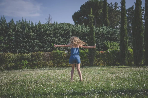 屋外のヒナギクの草地でのかわいい女の子 — ストック写真