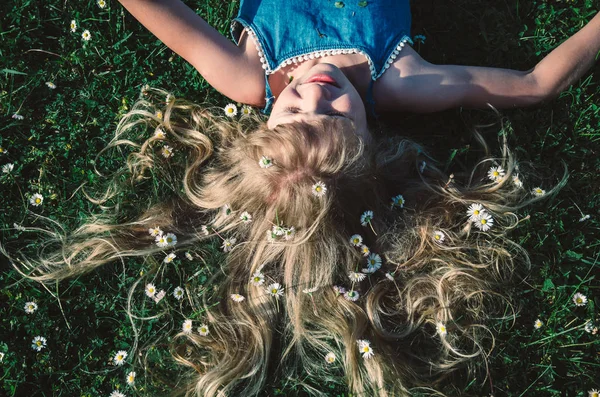 stock image lovely girl with long blond hair lying among daisies in green grass in meadow