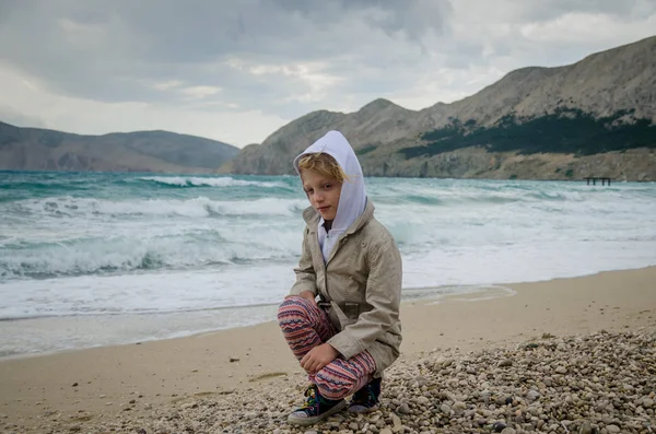 在恶劣天气中的岩石海岸线上的小孩 — 图库照片