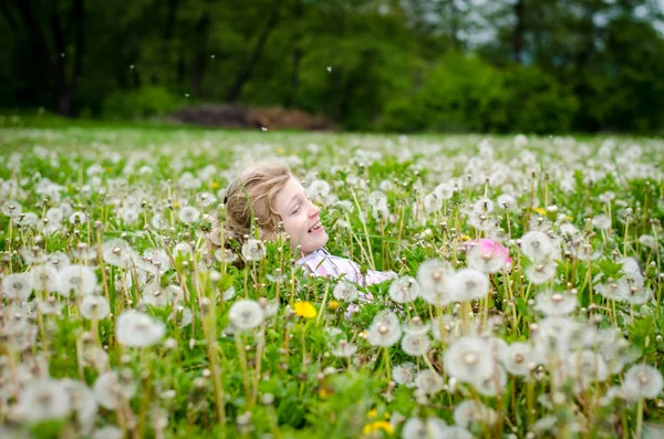 Criança bonito em flor dandelion flor prado — Fotografia de Stock