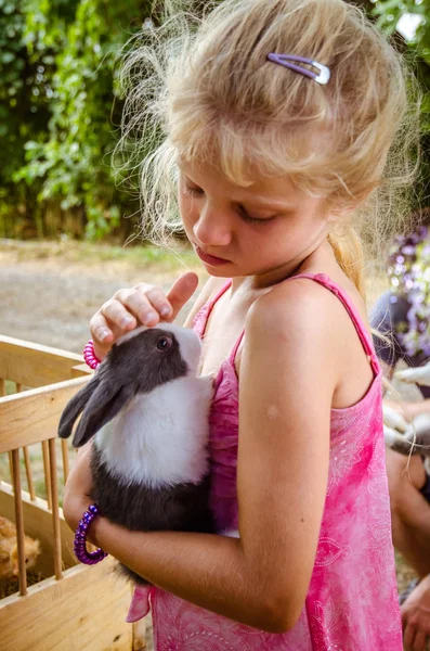 Precioso niño sosteniendo un conejo mascota —  Fotos de Stock