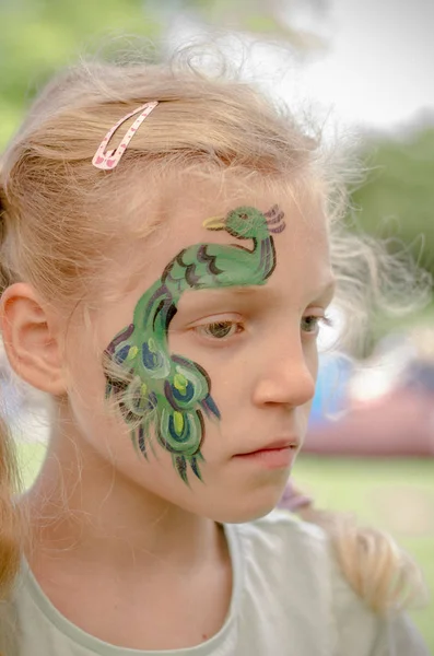 Smiling girl with face painting of peacock — Stock Photo, Image