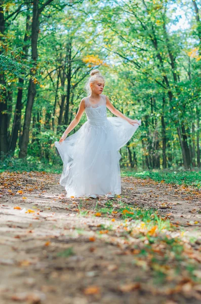 Очаровательный ребенок в длинном белом свадебном платье — стоковое фото