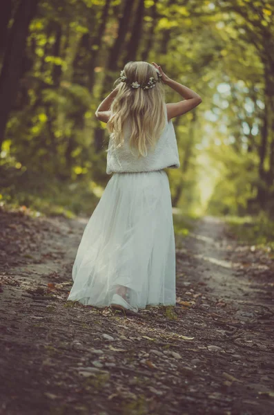 Imádnivaló szőke lány sétál a napsütéses napon a varázslatos erdőben — Stock Fotó
