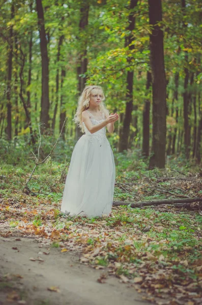 Entzückendes Kind im langen weißen Hochzeitskleid — Stockfoto